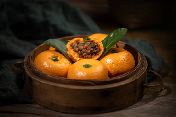 Orange shaped buns in a steamer on a dark background